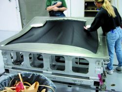 After application of mold release, the first two plies of prepreg are layed into the mold by hand, followed by the remaining four-ply preform. Source: MacLean Quality Composites