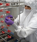 A Del West worker loads LS7 valves on racks prior to the wash process.